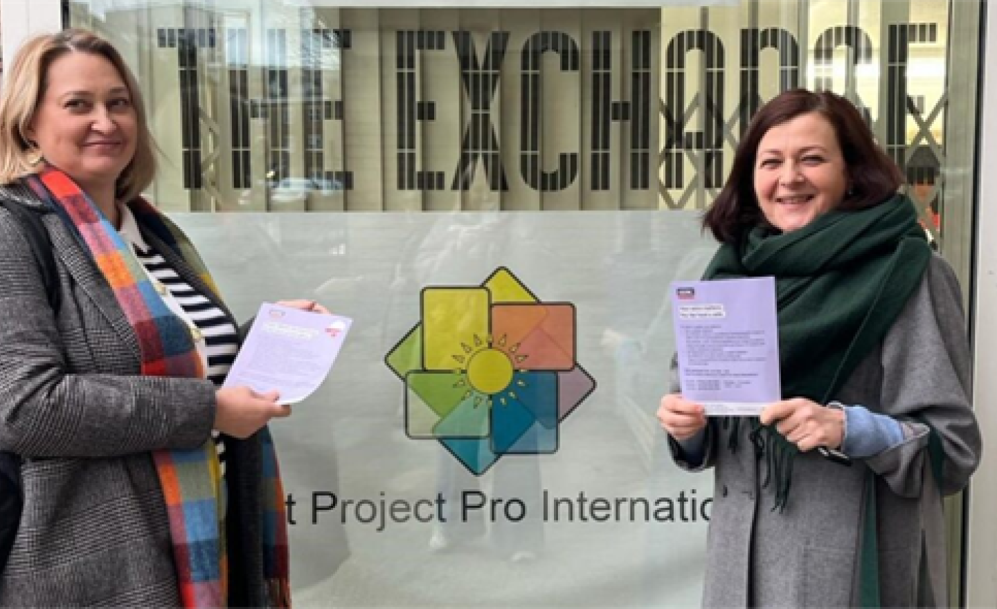 Two women holding information leaflets.