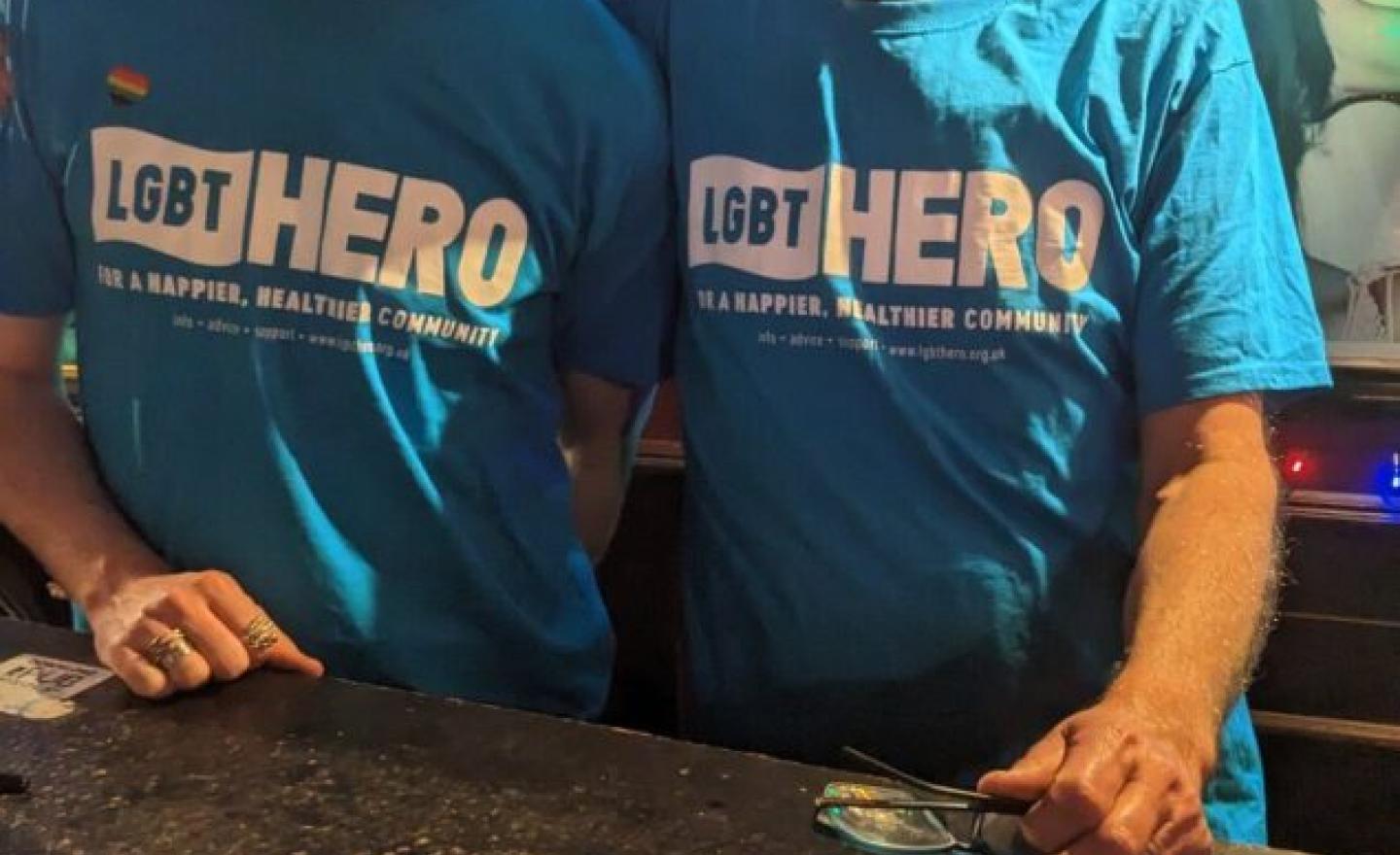 Two men wearing LGBT Hero t-shirts raising awareness of photo ID needed to vote and offering support for those who need to apply for photo ID