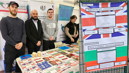People standing behind a table of community information leaflets including photo Voter ID