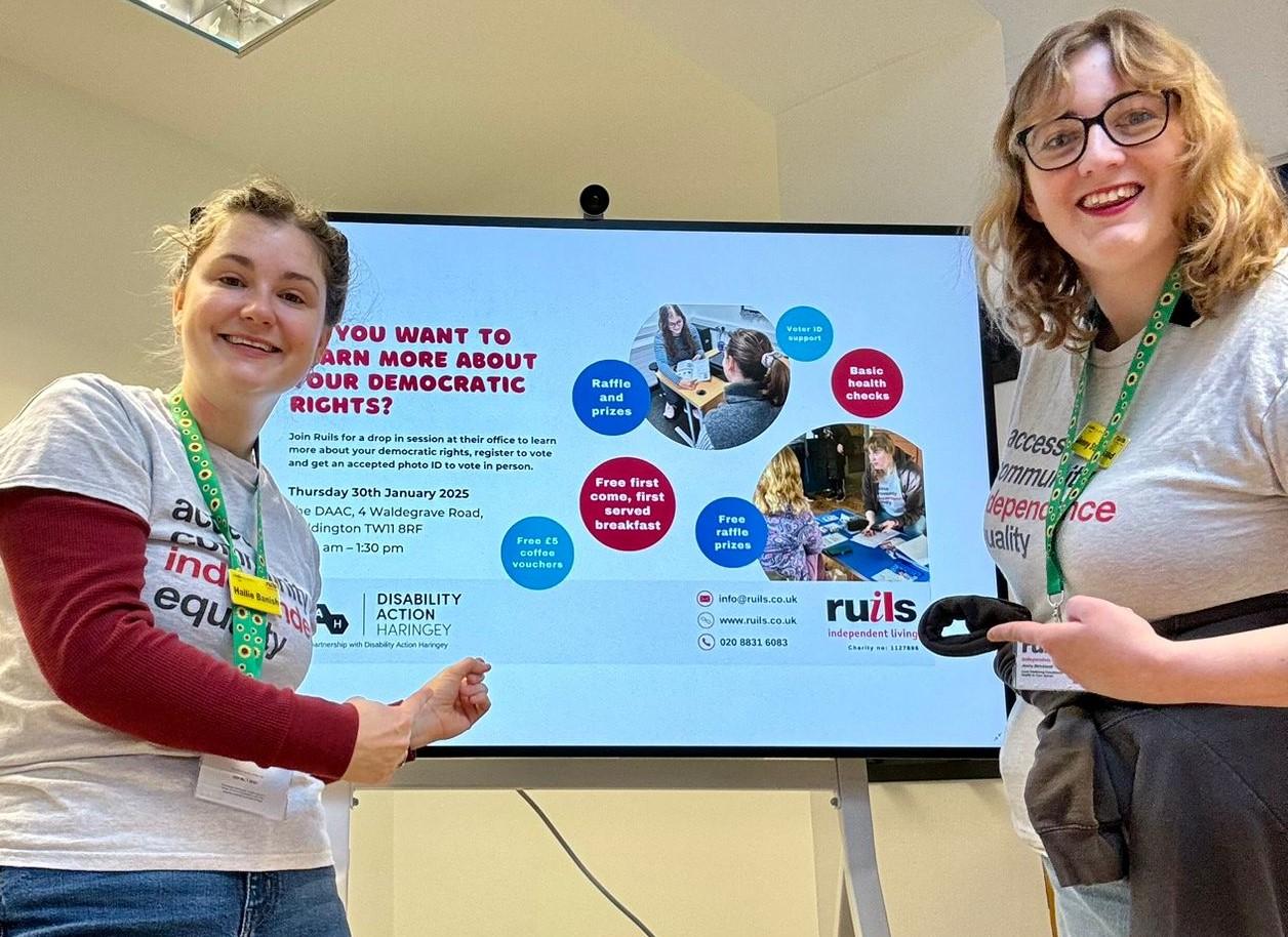 Ruils staff standing in front of a presentation screen about civic and democratic rights